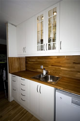 Fitted Kitchen with white cabinets and dark work surface